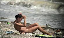 Mørkhåret nøgen pige går nøgen rundt på en strand