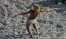 בלונדינית חובבת כיף רוקדת בחול